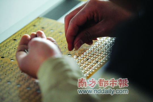 工人忙著安裝用于燈具發(fā)光的LED燈珠，這類工作處于LED燈具生產(chǎn)的最下游。資料圖